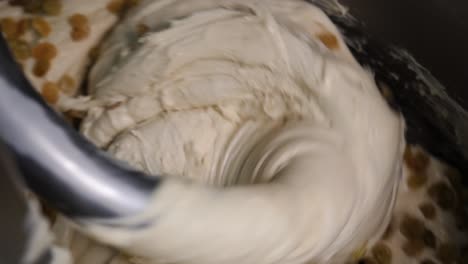 mixing dough with raisins in a stand mixer