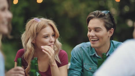 friends drinking beer and toasting at outdoor party