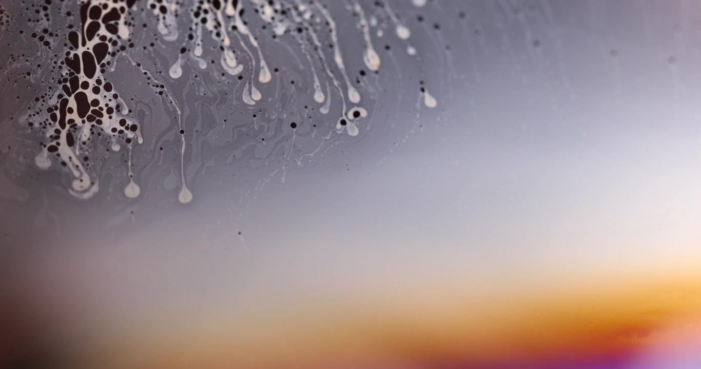 High-detail extreme macro footage capturing thin-film optical interference and fluid dynamics on a soap bubble surface.