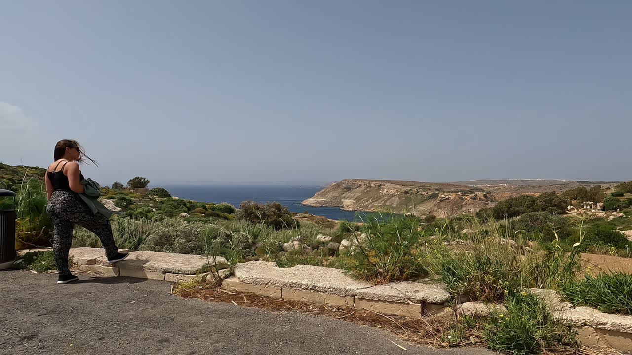 una mujer hermosa disfruta del paisaje natural de la isla de malta, vista trasera