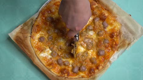 Overhead-shot-of-woman's-hands-cutting-pizza-with-cutter