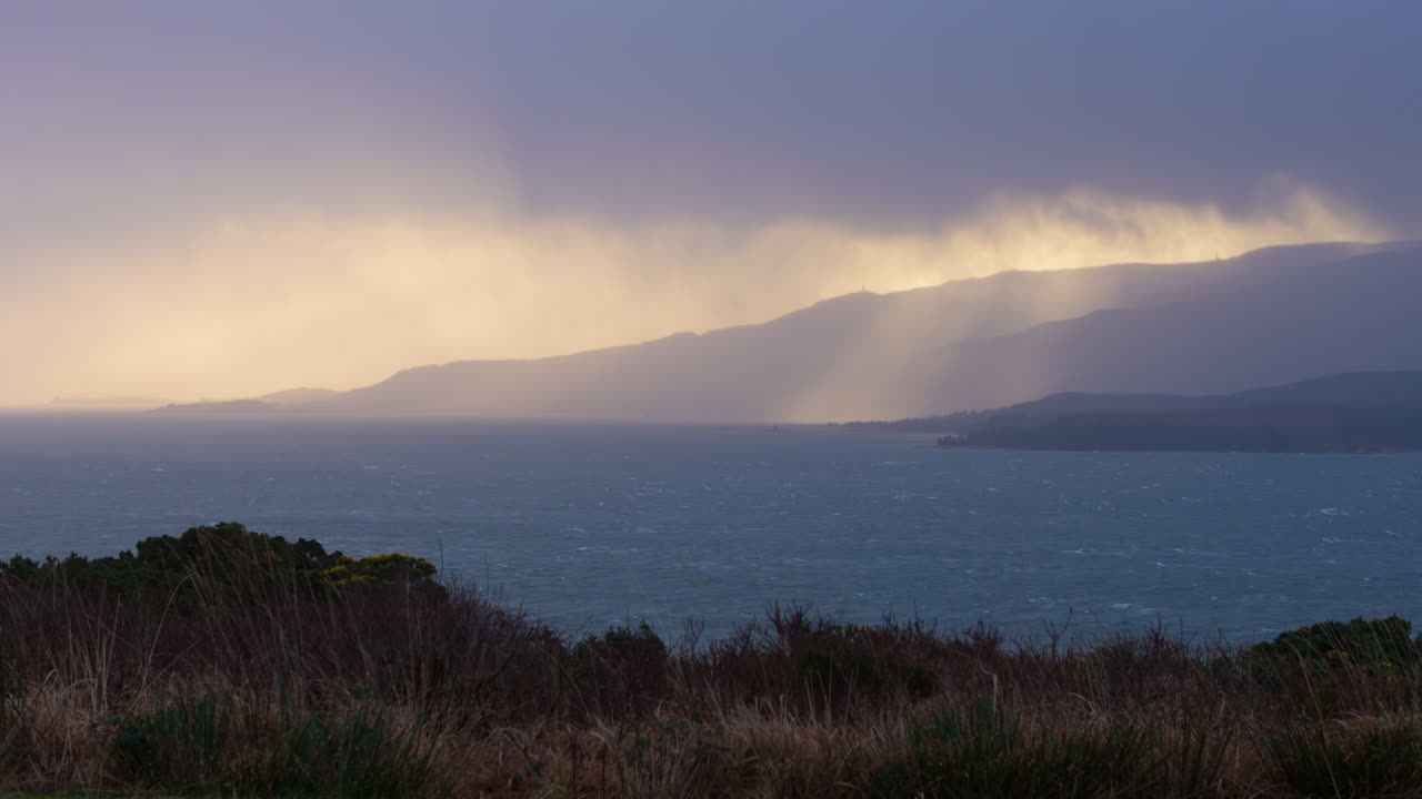 Elevated view from Scotland West Coast toward Isle of Mull on stormy day, sunset