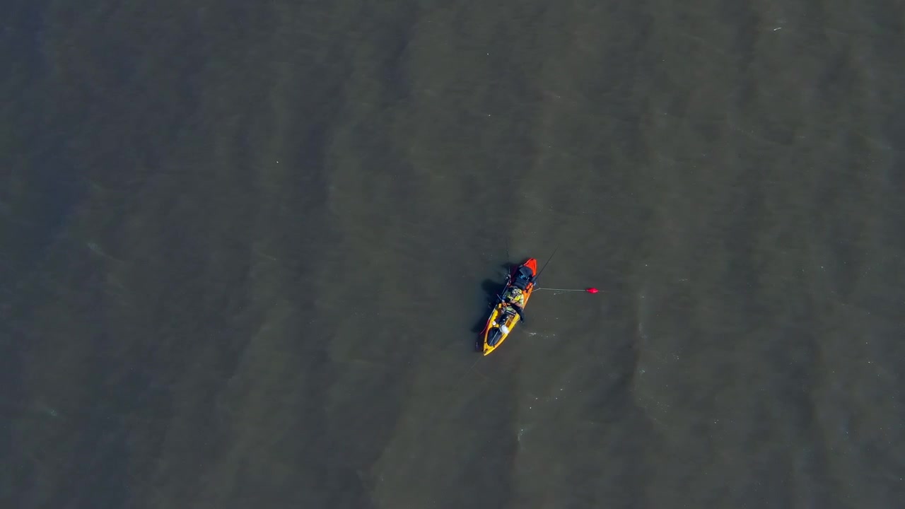 A man in a canoe fishing for food