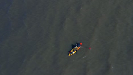 a man in a canoe fishing for food