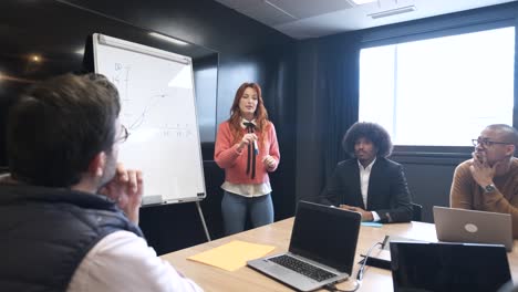 group of colleagues listening to female speaker