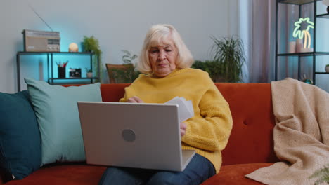 stressed senior woman looking at unpaid bank debt loan doing paperwork planning budget, throws bills