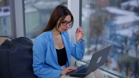 woman working on laptop by window