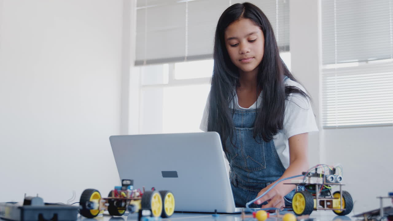 estudiante de construcción y programación de vehículo robótico en la clase de codificación de computadoras después de la escuela