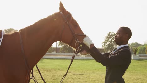 Hombre-Afroamericano-Mirando-Su-Caballo-De-Doma