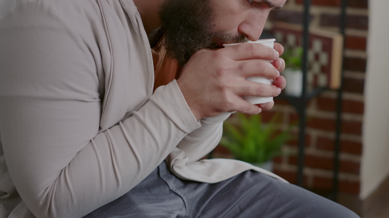 Close up of man shaking and drinking cup of coffee at aa therapy session