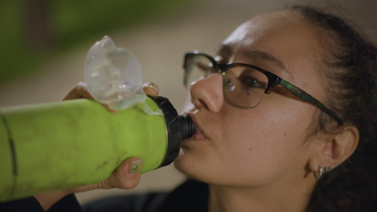 Cyclist Refuels After Ride, Latin Cyclist Restores Hydration Following Vigorous Park Cycling Session, Rejuvenated Cyclist Replenishes Fluids And Energy After Intense Ride Under Park Lights