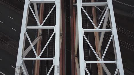 video cinematográfico de drones de las vías del tren en un puente sobre la carretera del automóvil