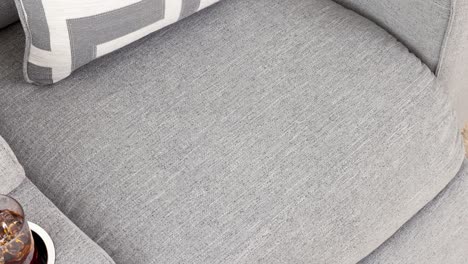 camera zooms into grey cushion and decor atop upholstered seat