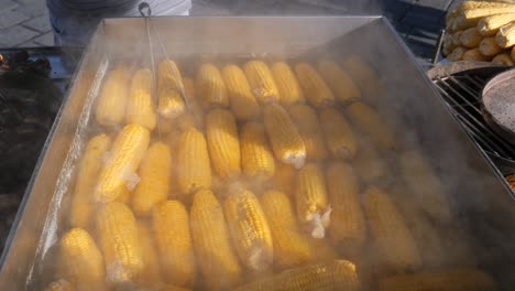 boiling corn on the cob at a street food stall