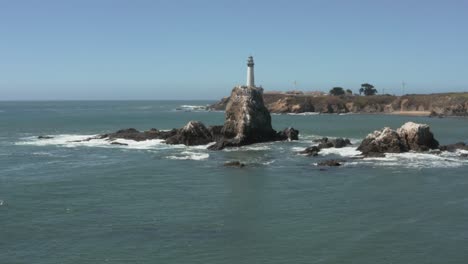 aerial of pigeon point lighthouse flying over rocks on pacific coast highway near half moon bay on california coast