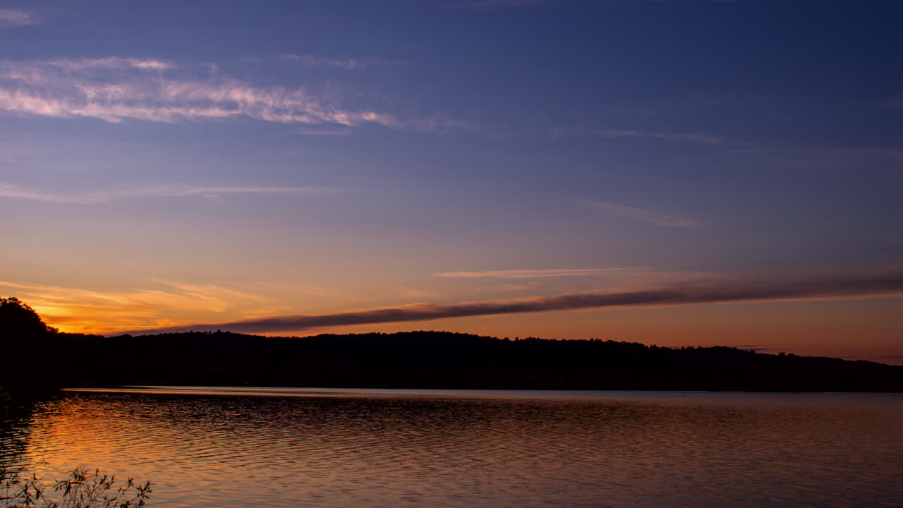 A sunset over a lake in the summer