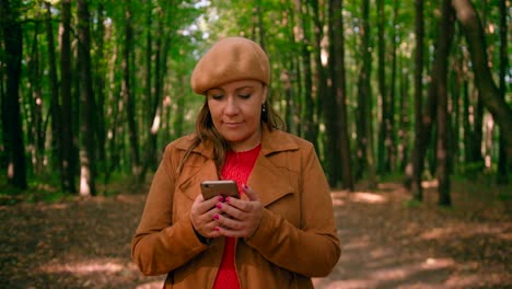 Close-up-shot-of-women-looking-into-mobile-and-walking-in-the-forest-trail