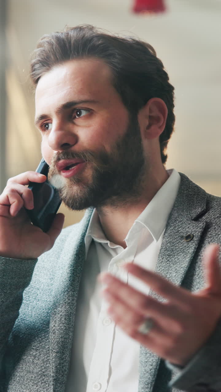 Smiling Bearded Man Talking on Smartphone in a Professional Setting