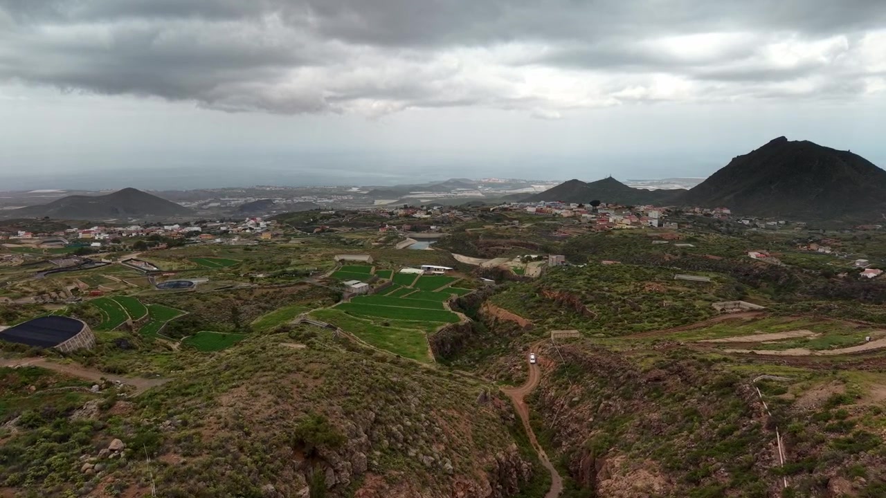 Veduta aerea di campi verdi, burroni e colline vulcaniche sotto cieli nuvolosi
