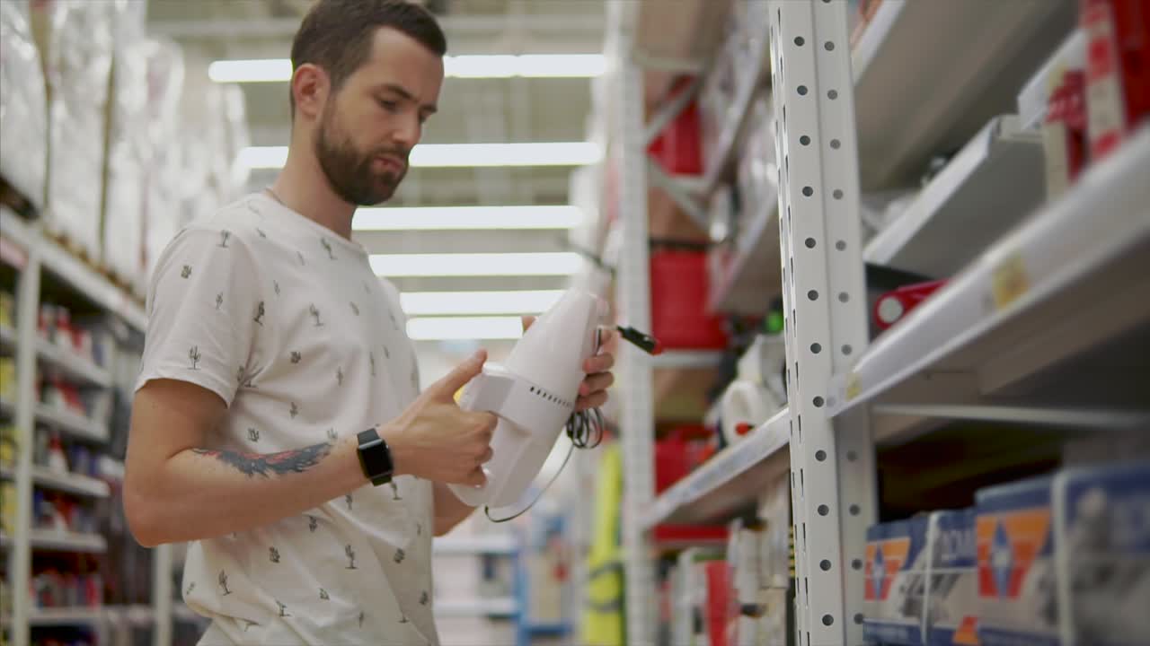 hombre comprando un aspirador de mano en una tienda