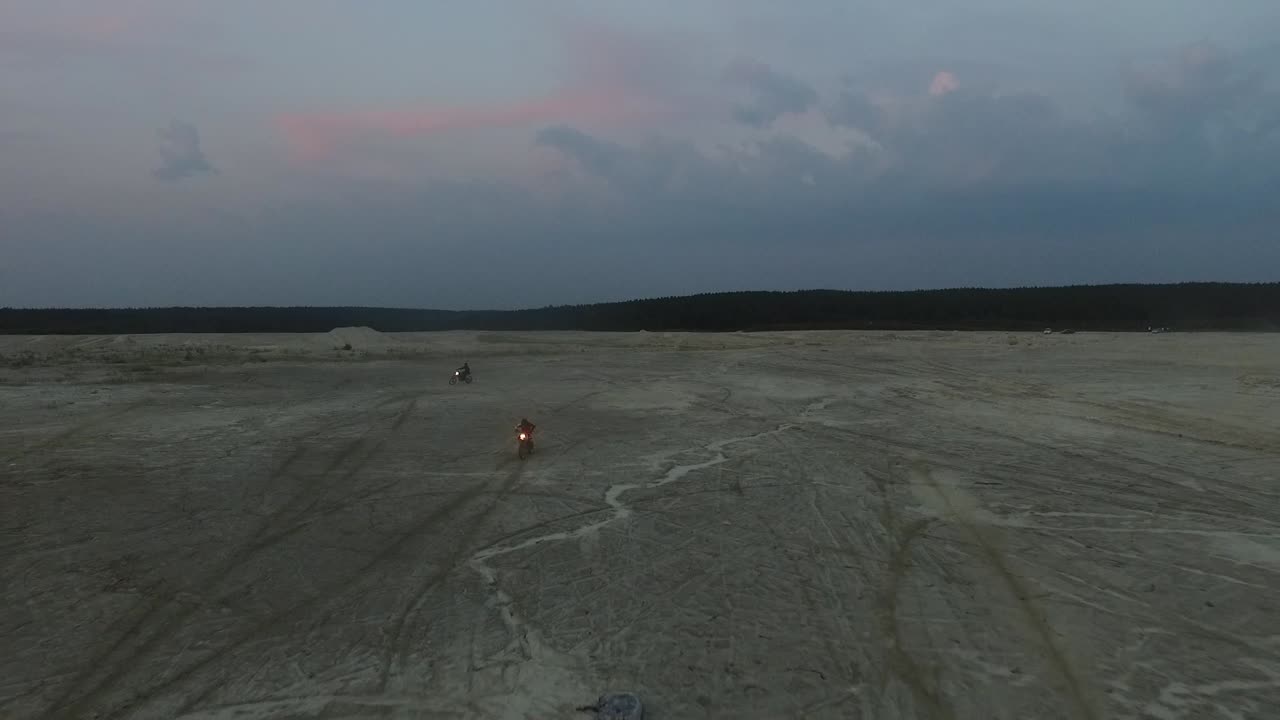 motocicletas montando a través de una cantera al anochecer