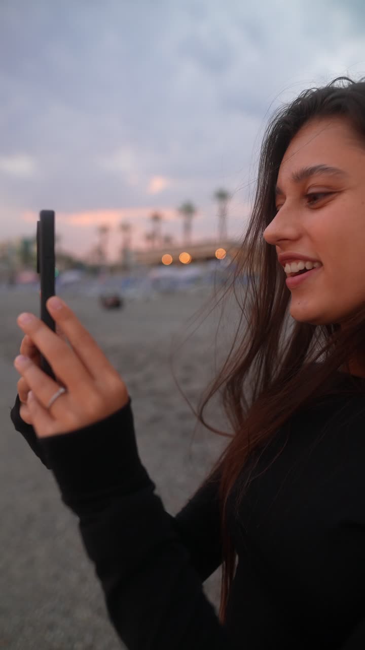 mujer tomando fotos en la playa durante el atardecer