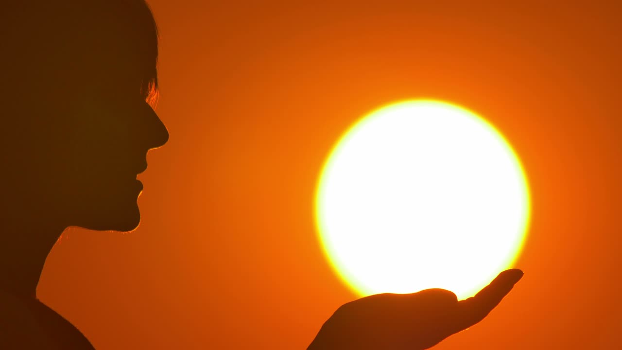 женщина (силуэт) стоит на ярком солнце и небесном фоне.