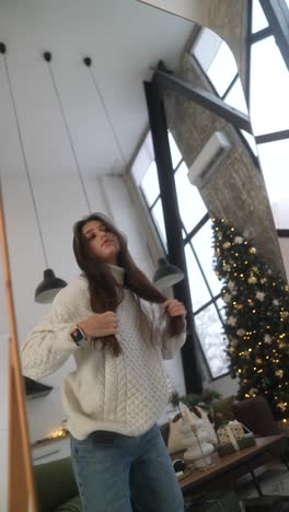 woman styling hair in front of a mirror during christmas