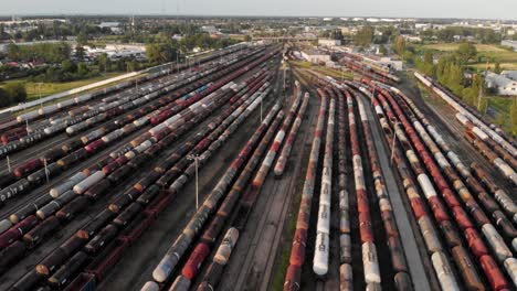 Toma-Aérea-Que-Muestra-Un-Gran-Depósito-De-Trenes-Con-Muchos-Trenes-De-Carga-Coloridos