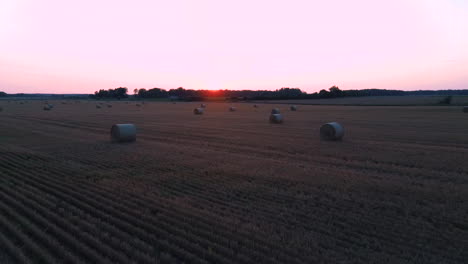 flying above the field with hay rolls sunrise