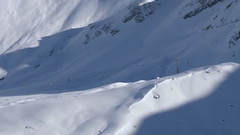 Ski-lifts-high-altitude-in-the-snowy-alpines,-sunny,-winter-day-in-Austria---static-view