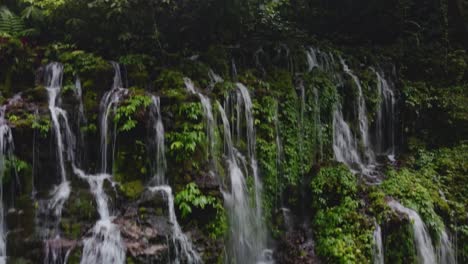 drone footage of banyu wana amertha waterfall in bali. lush tropical jungle, cascading water, and peaceful natural scenery.