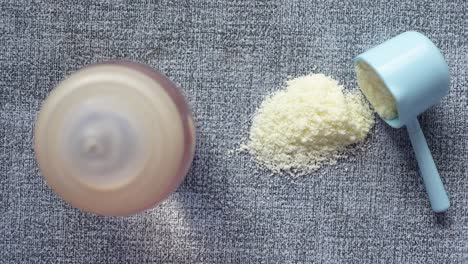 primer plano de leche en polvo para bebés y cuchara en el fondo de azulejos