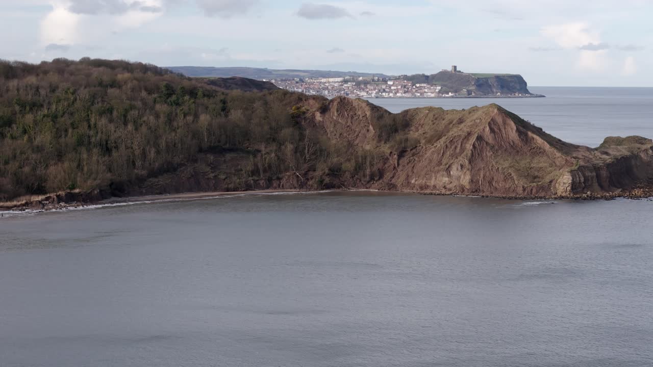 북 요크셔 해안선의 공중 사진과 멀리 있는 스카버러 마을