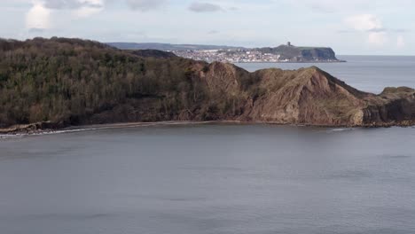 aerial reveal of north yorkshire coastline with scarborough town in the distance