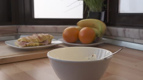 dropping slices of green grapes to yogurt in a bowl - food for breakfast - slow motion