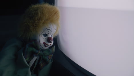 antique clown doll by a vintage tv