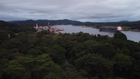 Volando-Sobre-La-Selva-Tropical-Con-Vista-Del-Barco-De-Carga-Navegando-En-El-Río-Chagres-Cerca-De-La-Base-De-La-División-De-Dragado-En-El-Canal-De-Panamá,-Gamboa,-Panamá