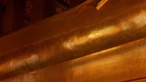 golden statue of reclining buddha in bangkok temple