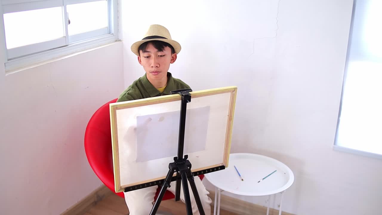 Creative young asian artist painting on canvas