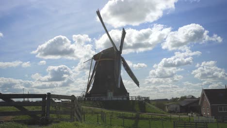 view of old and unique windmill in netherlands on a sunny day in the farm - wide shot