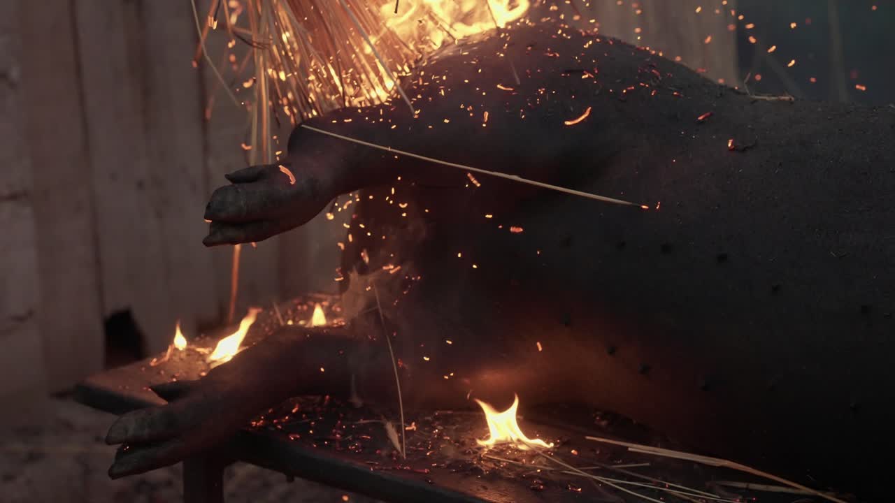 Burning straw singes pig carcass in traditional rural Portugal pig butchering