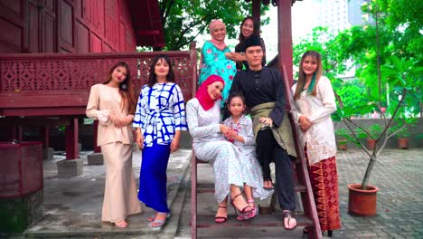 a group of malay people at the wooden house celebrating hari raya festive