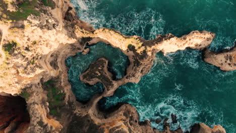 AERIAL:-Cliffs-and-rocks-in-Portugal-from-above-with-blue-water-moving-around