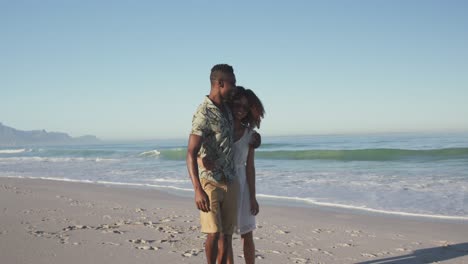 african american couple walking side by side at beach