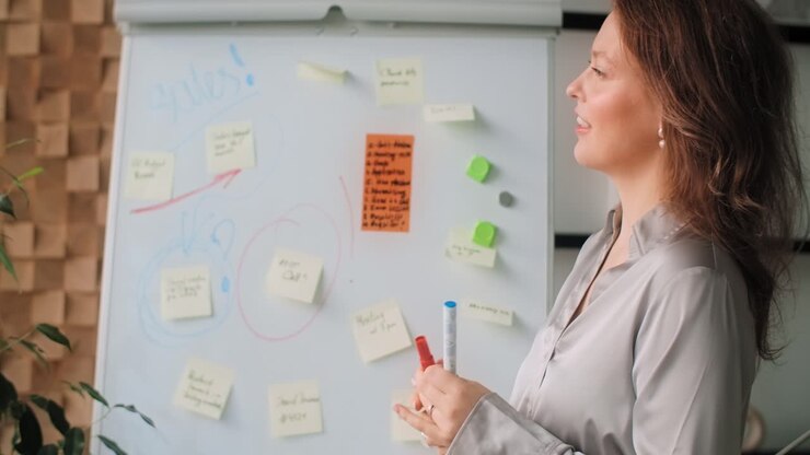 Kvinde på et møde, brainstormer på whiteboard