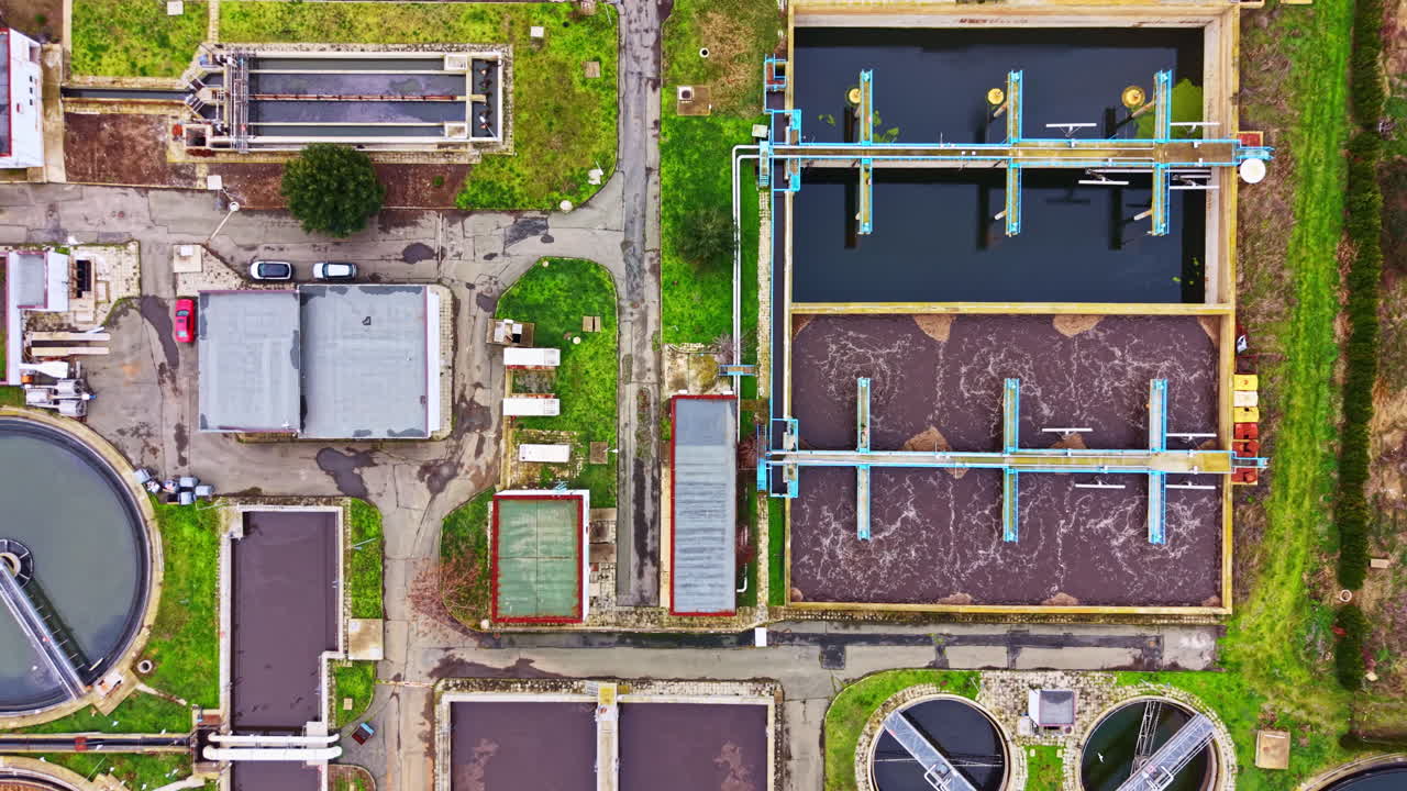 Wastewater treatment facility overview with tanks and equipment visible at a specific location during daylight hours