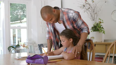 father helping daughter with homework at table