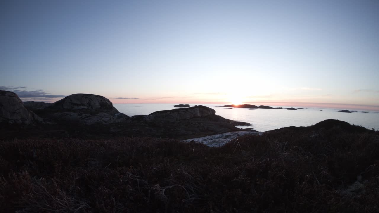 lapso de tiempo de puesta de sol de gran angular a lo largo de la costa de noruega en telavaag sotra fuera de bergen - día a noche con el sol cayendo detrás del horizonte
