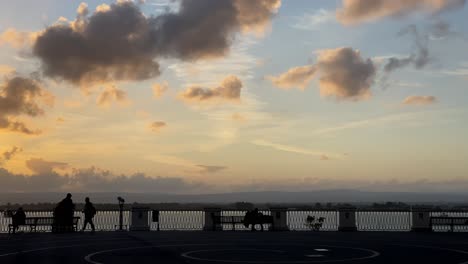 Silhouette-Von-Menschen,-Die-Einen-Verträumten-Sonnenaufgang-Oder-Sonnenuntergang-An-Der-Städtischen-Promenade-Genießen